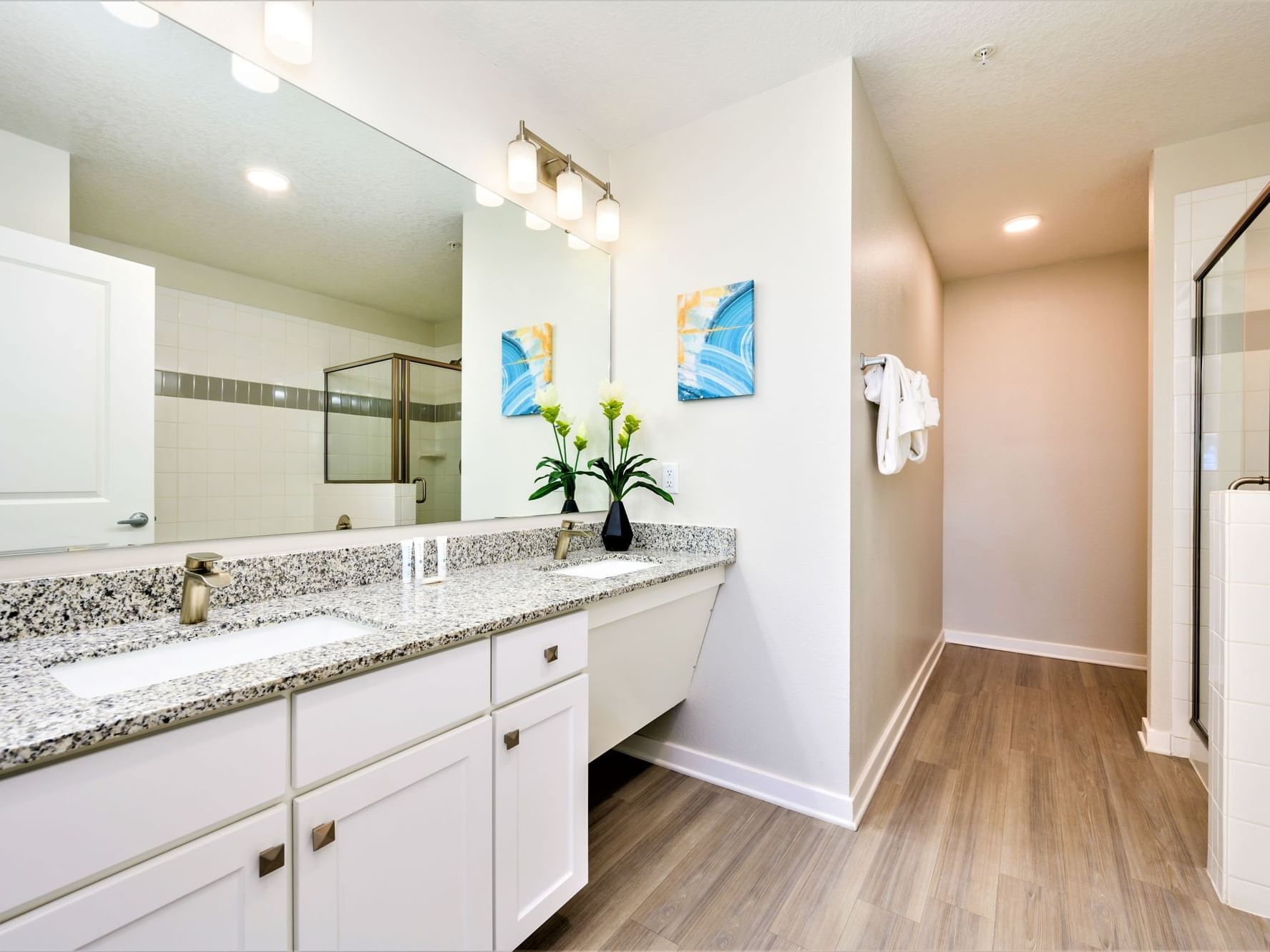 Spacious accessible bathroom with granite vanity, large mirror, and wood-style flooring at Vista Cay Resort By Millenium.