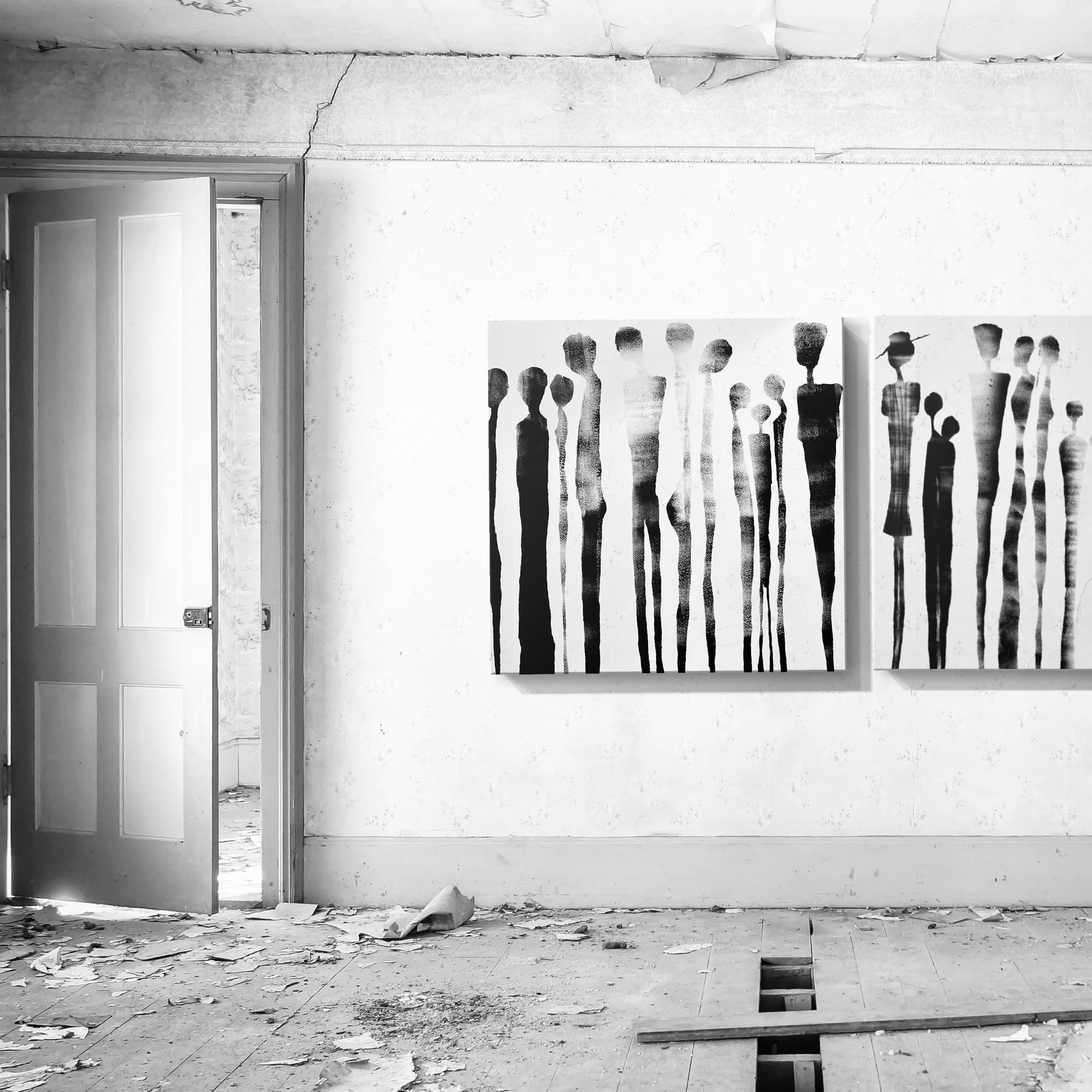 Black and white artwork depicting people on wall of a dilapidated room with an open door.