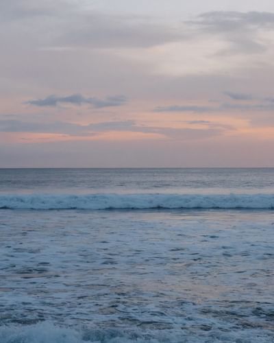 Serene view of ocean waves breaking on the shore at pastel sunset near Morgan’s Rock Reserve & Ecolodge