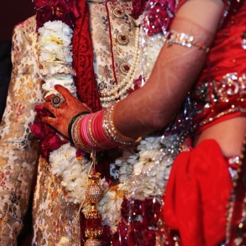 Bride gives floral garland to her husband which is also known as Jai Mala, a Hindu wedding tradition 
