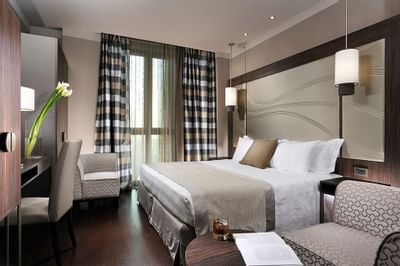 Bed & furniture in Deluxe King Room at Uptown Palace