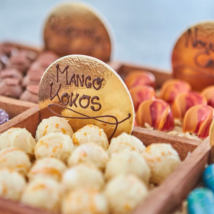 Scatole di cioccolatini di vari colori con un disco d'oro che dice 