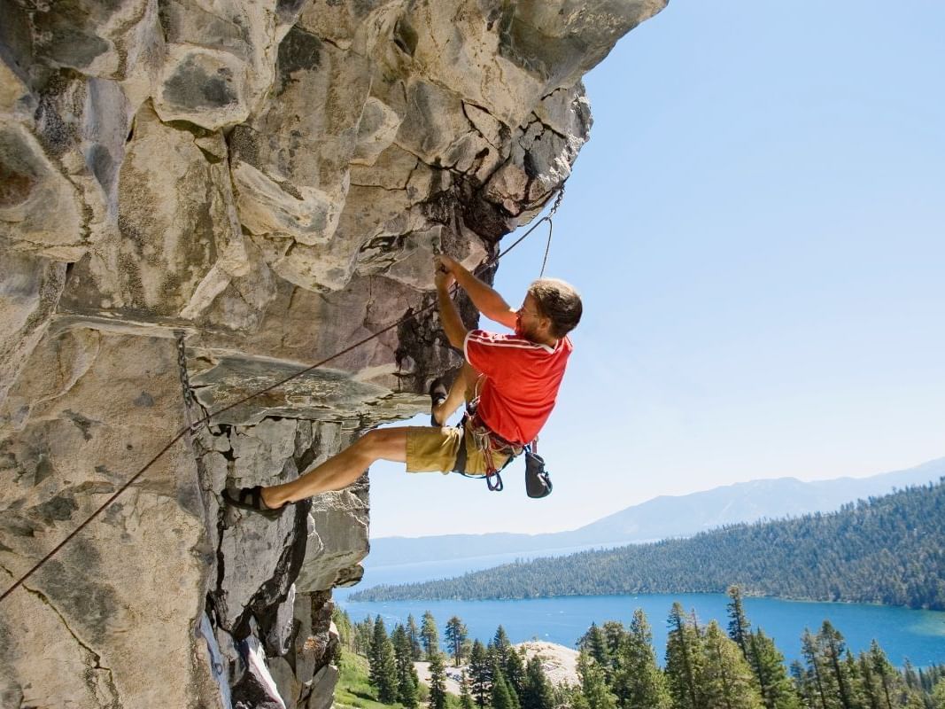 Rock climber lead sport climbing on a bolted route at Mayhem Cove, Emerald Bay, Lake Tahoe, CA