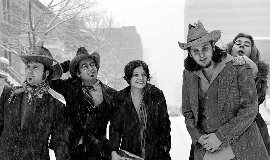 Five people in vintage clothing and cowboy hats pose together on a snowy Montreal street at Warwick Le Crystal Montreal