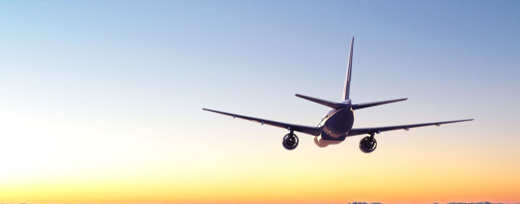 Airplane in sky with sunset in background