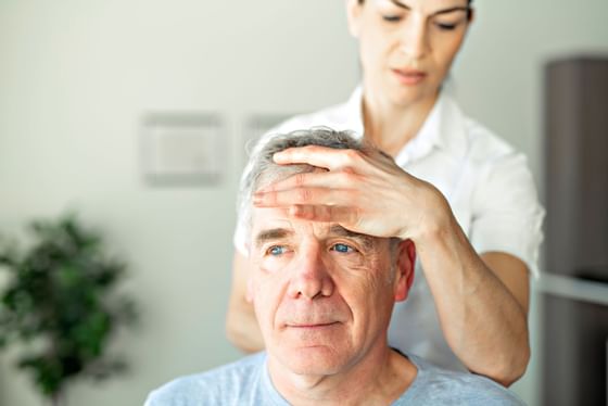 Woman feeling patient's forehead