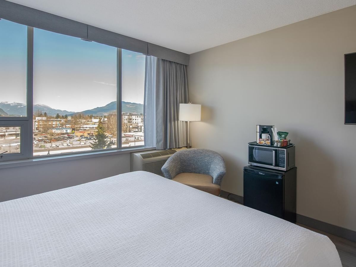 Spacious room with large window, microwave, TV, and queen beds.