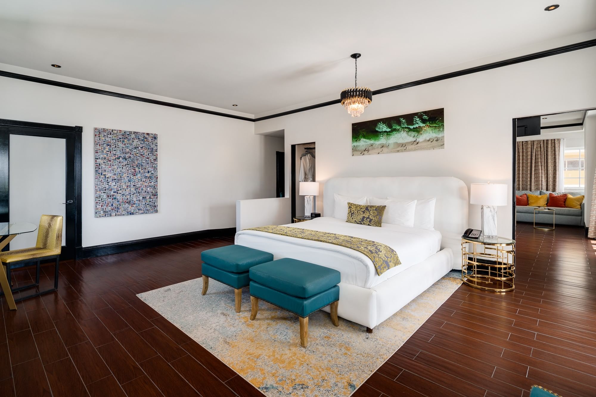 A spacious hotel suite with a king-sized bed, seating area, and desk
