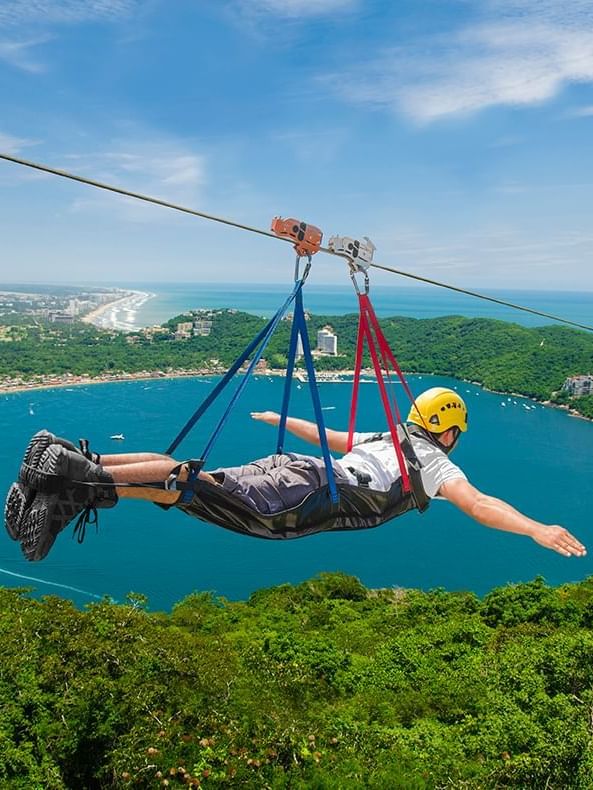 A man on a zipline at Xtasea Zipline near Mundo Imperial