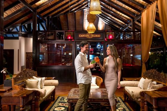 Couple toasting cocktails in the lobby at Hideaway Rio Celeste