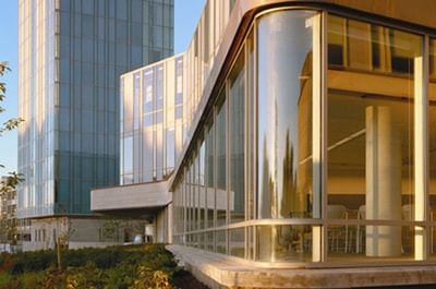 Exterior view of the Schulich School of Business, with a modern, curved glass facade and landscaping.