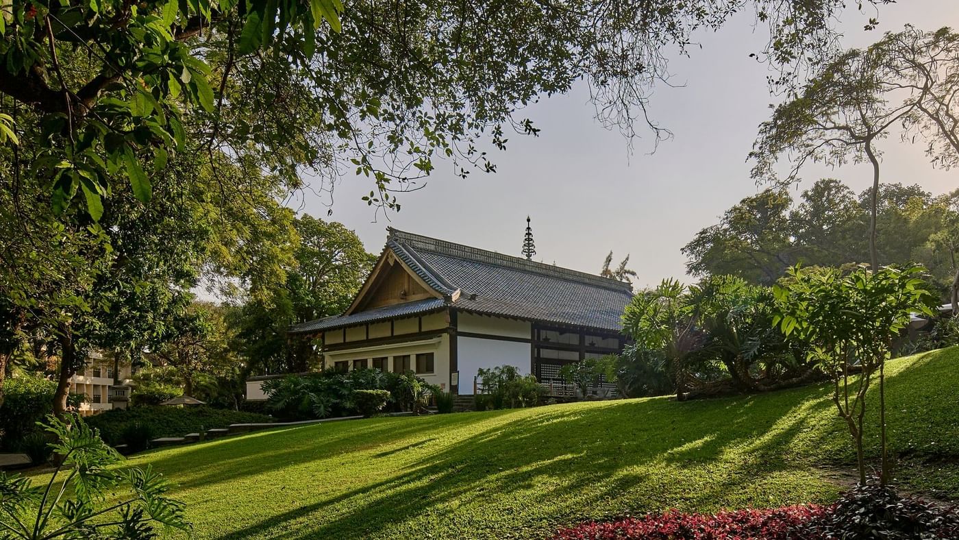 Teatro Kabuki with a traditional tiled roof nestled in a serene, manicured garden near Grand Fiesta Americana