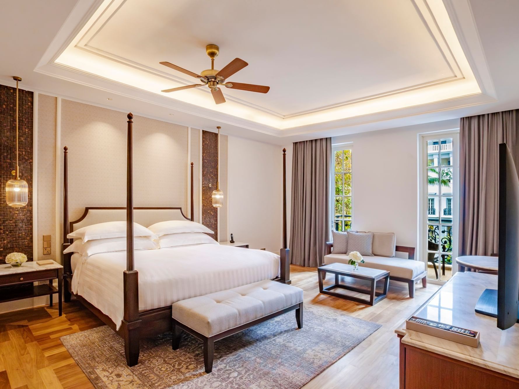 TV facing the king bed in Merchant Room with wooden floors at Danna Langkawi Hotel