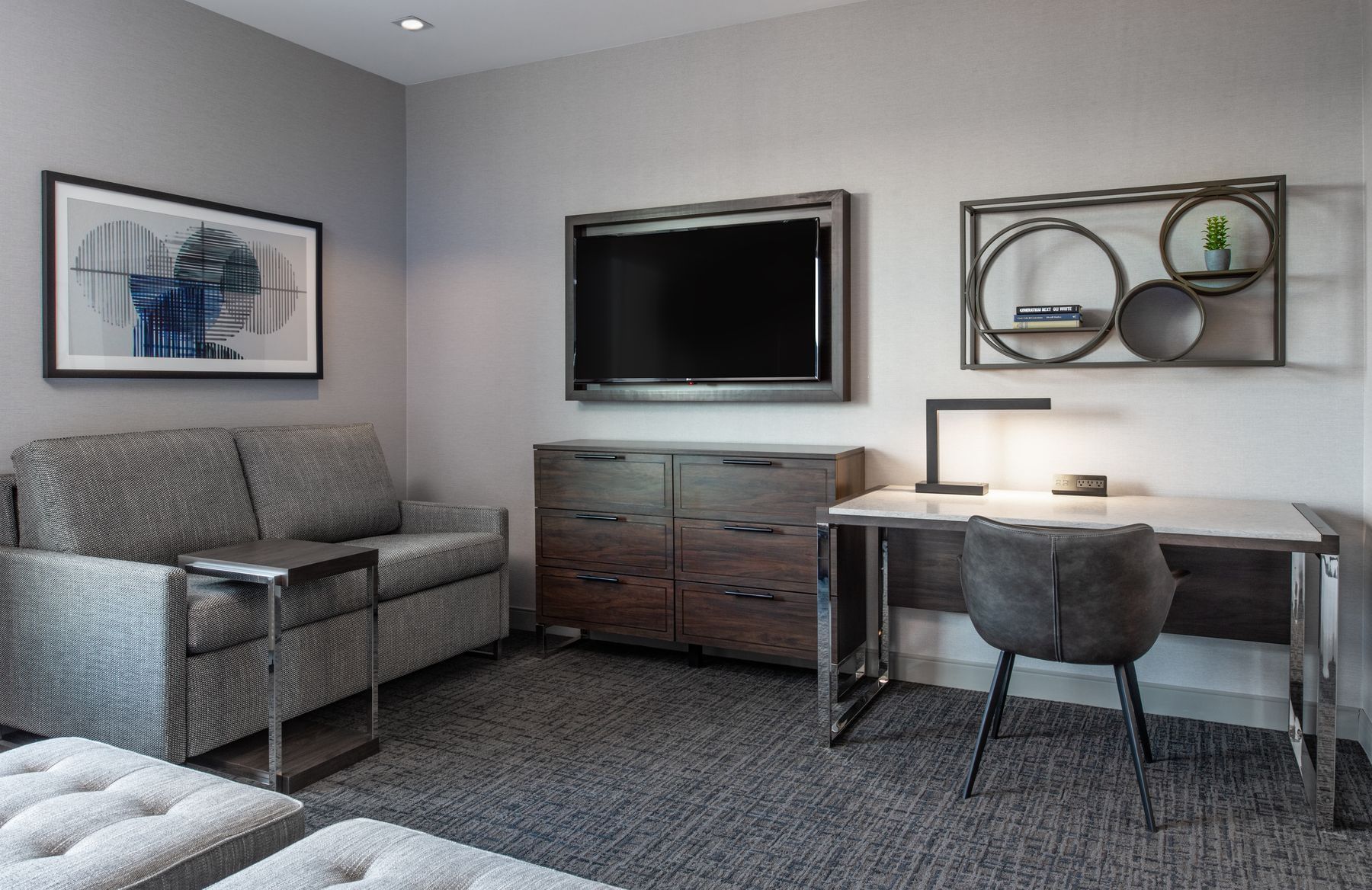Hotel room living space with business desk and couch.