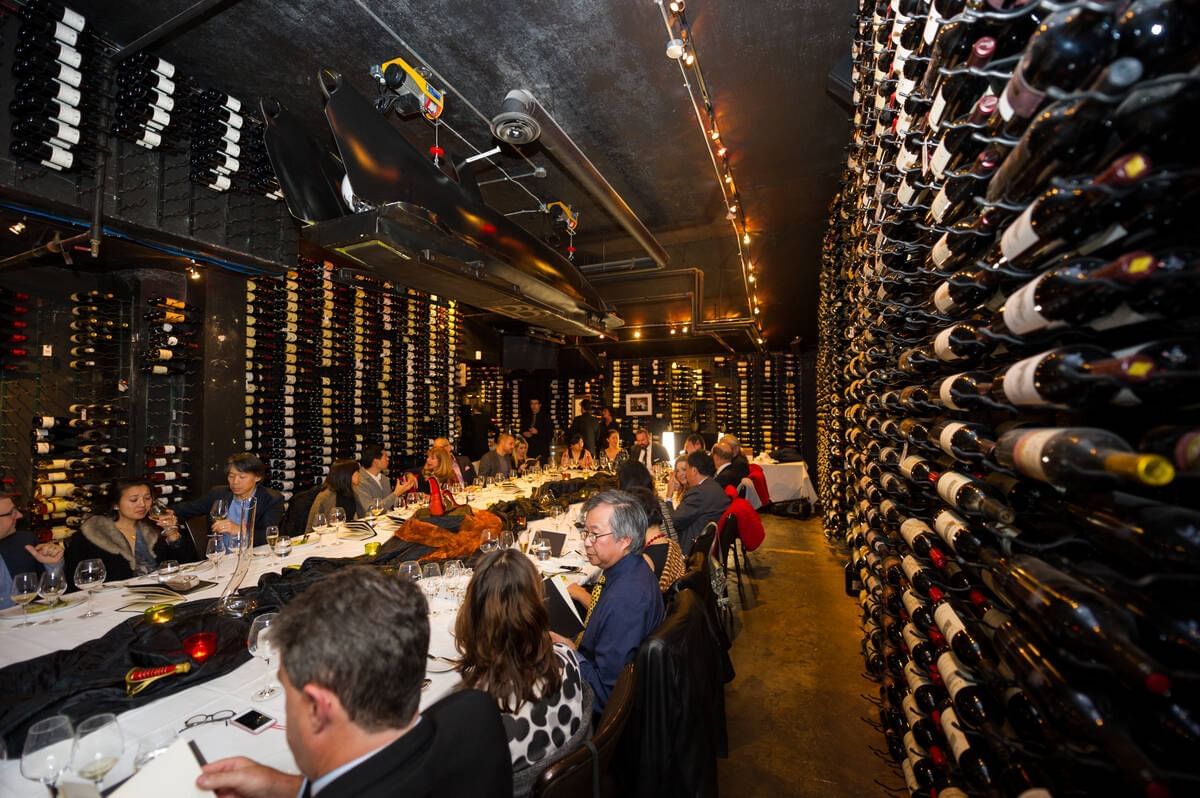 People dining in a bar with walls made from wine bottles near Blackcomb Springs Suites