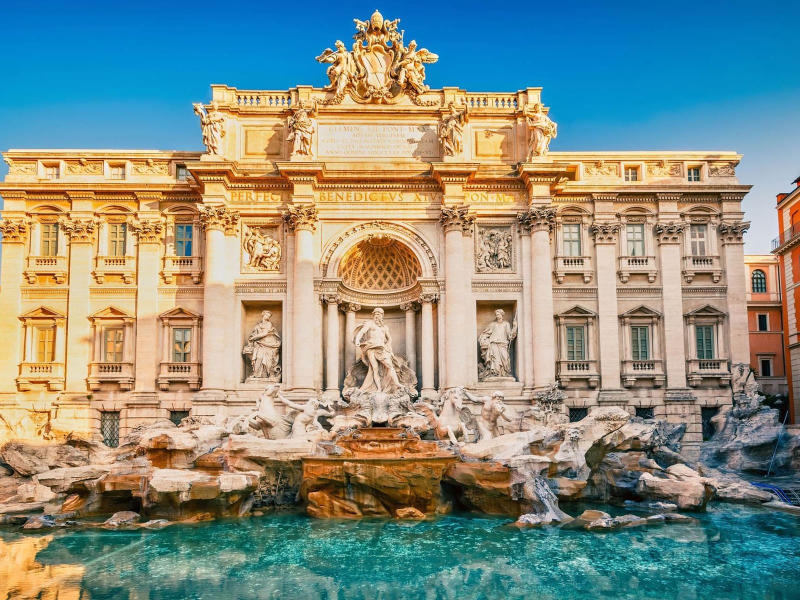 Dazzling Trevi Fountain with grand sculptures, cascading water & pool under a clear sky near The Guardian Hotel