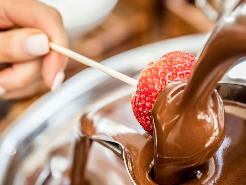 Strawberry being dipped into chocolate in Mesh restaurant at Crown Hotel Melbourne