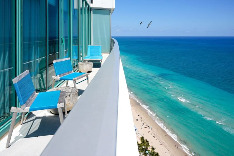 Balcony view from high-rise with blue chairs overlooking the ocean at Diplomat Beach Resort