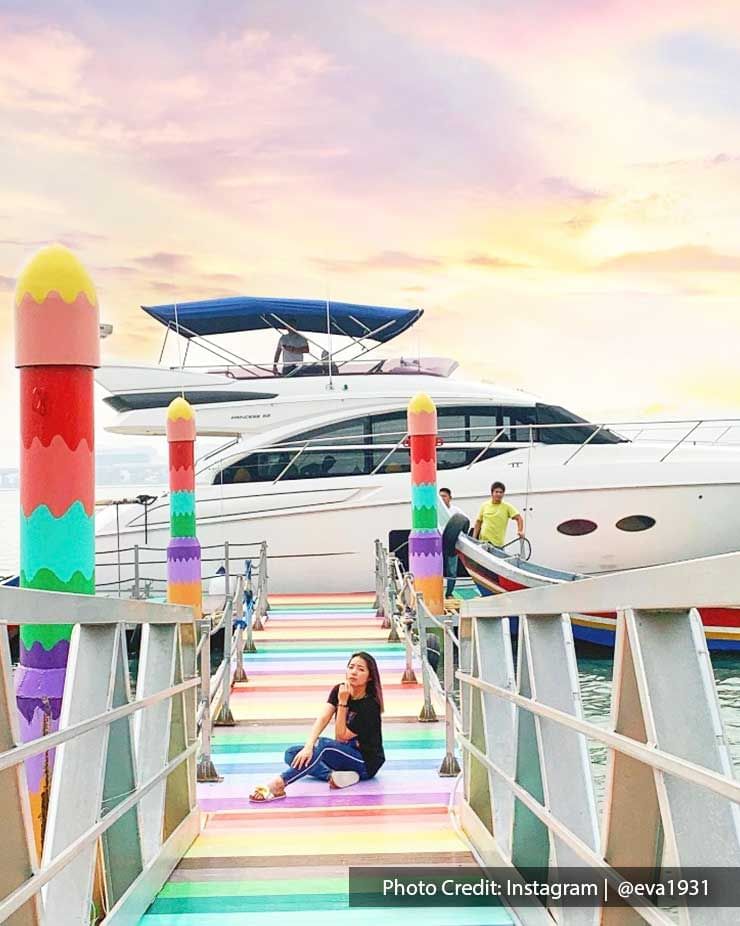 A lady was sitting on a rainbow jetty pier at Pulau Jerejak - Lexis Suites Penang