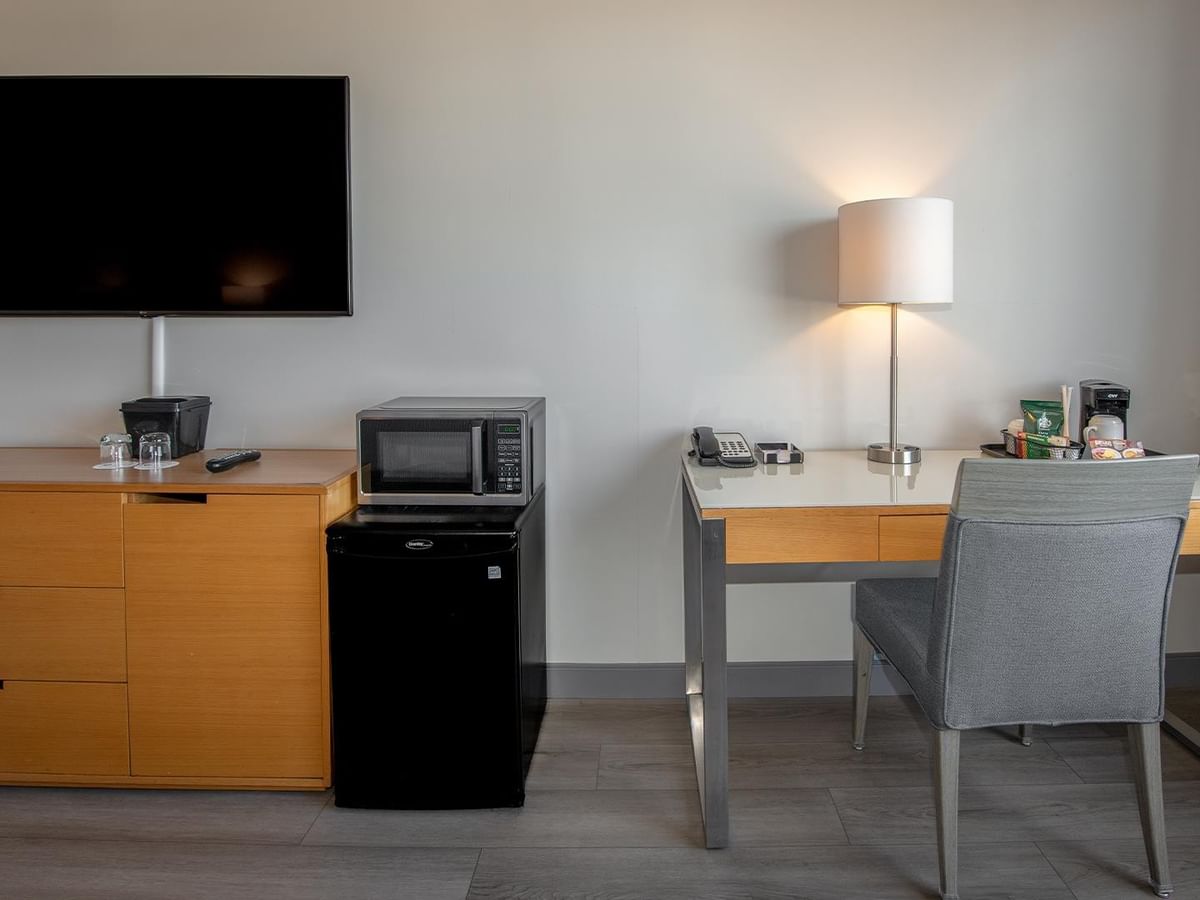 Hotel room with desk, TV, and mini-fridge at Coast Chilliwack Hotel by APA.