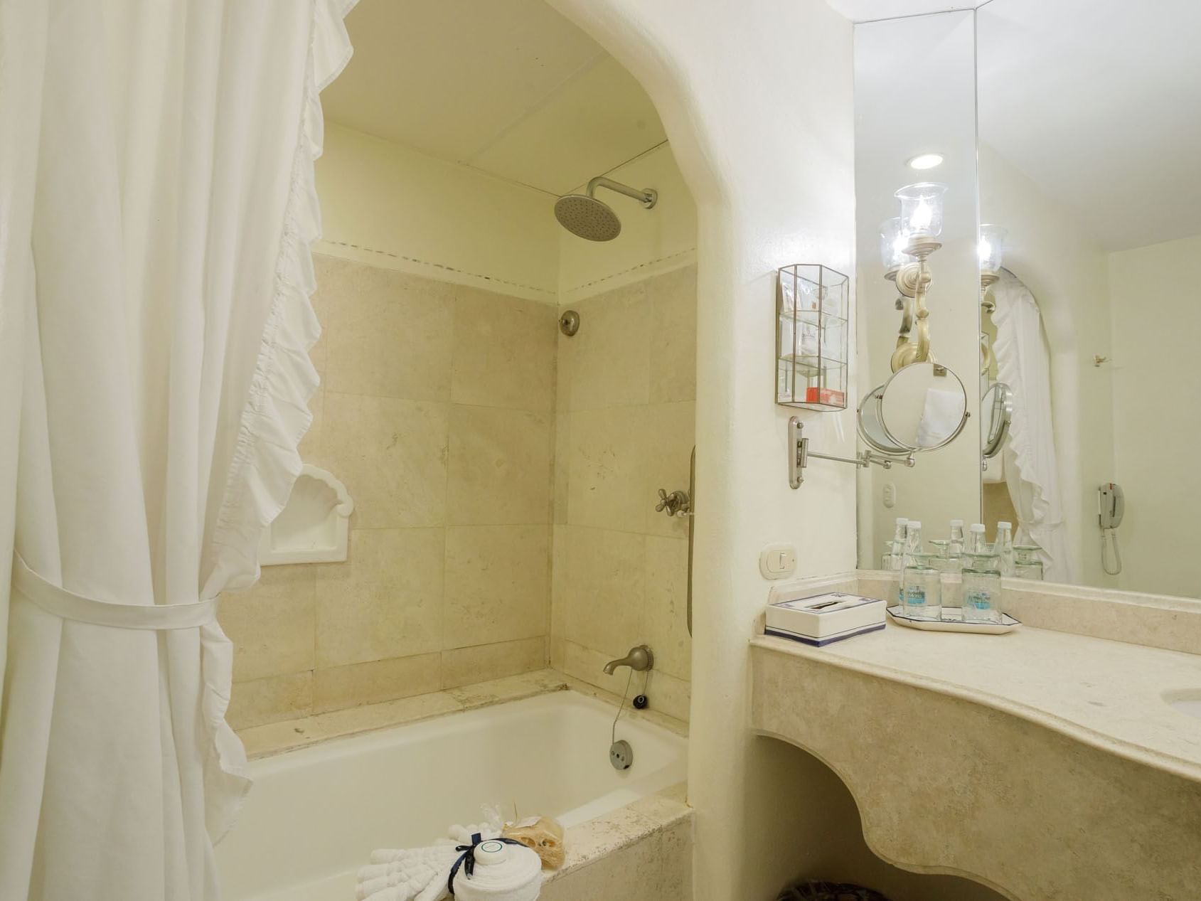 2 Double Master Suite marble bathroom showing a rainfall shower and elegant vanity lighting at Quinta Real Acapulco