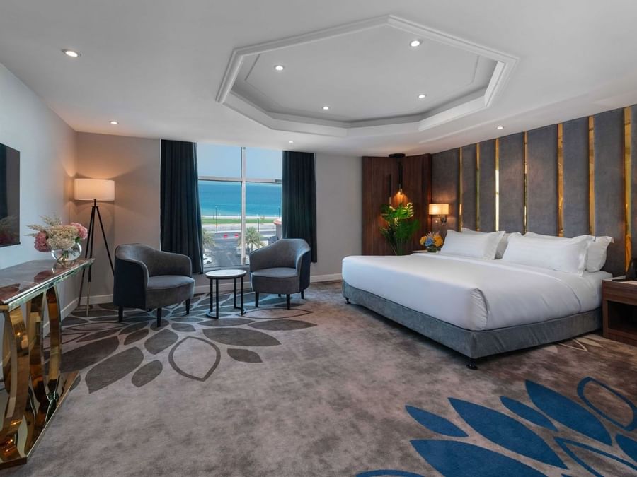 Royal Suite Sea View features King Bed & two grey armchairs by a window at Warwick Al Jubail