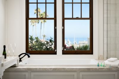 Bath tub by the window with provided towels in Philip Knight Suite at Hotel Atwater