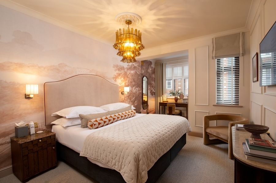 Bed with side tables and a work desk near window in One Bedroom Apartment at The Capital Hotel, Apartments and Townhouse