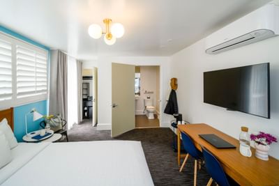 Bed and work area with bathroom in Queen with a View Room at Becks Motor Lodge