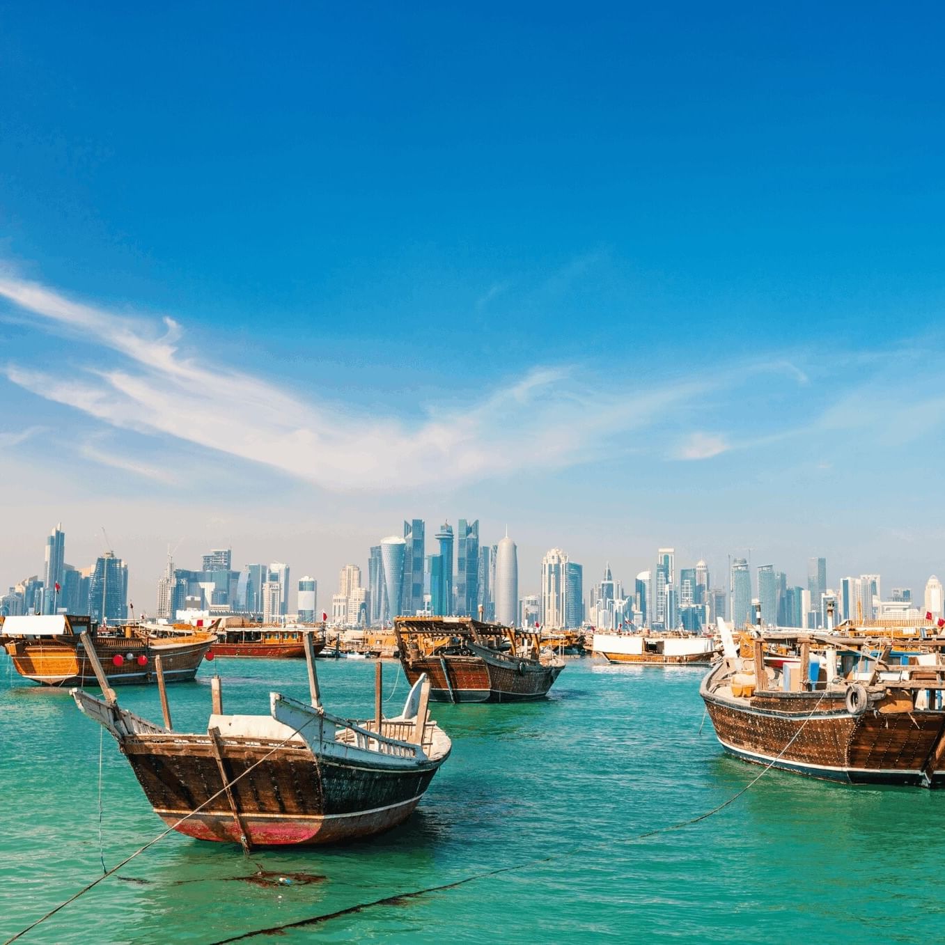 Doha Corniche with Wooden boats floating on turquoise water by a modern city skyline near Warwick Doha Hotel