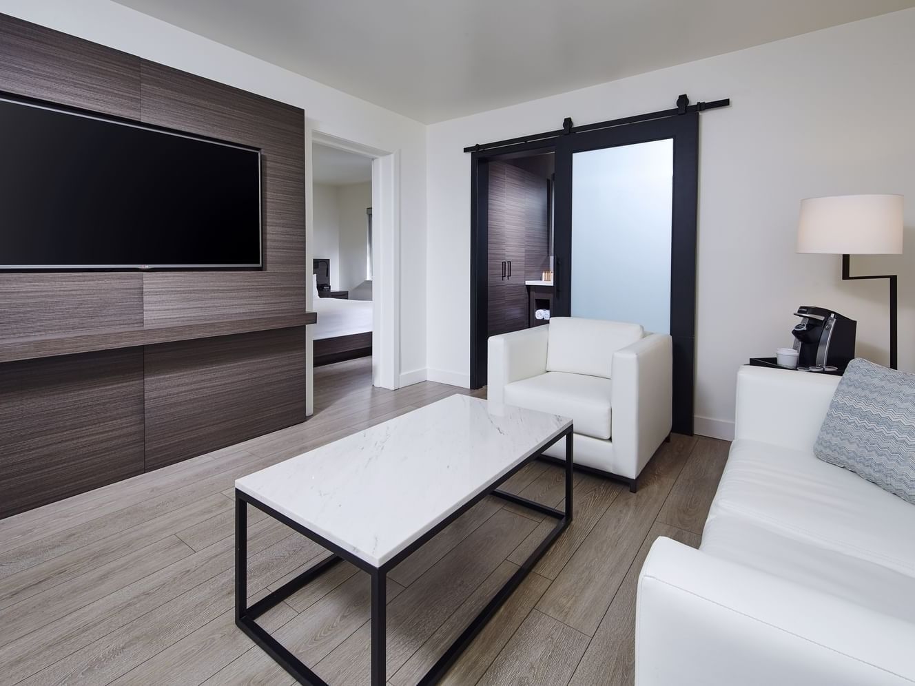 A couch & wall mounted tv in Suite King at The Nest Palo Alto