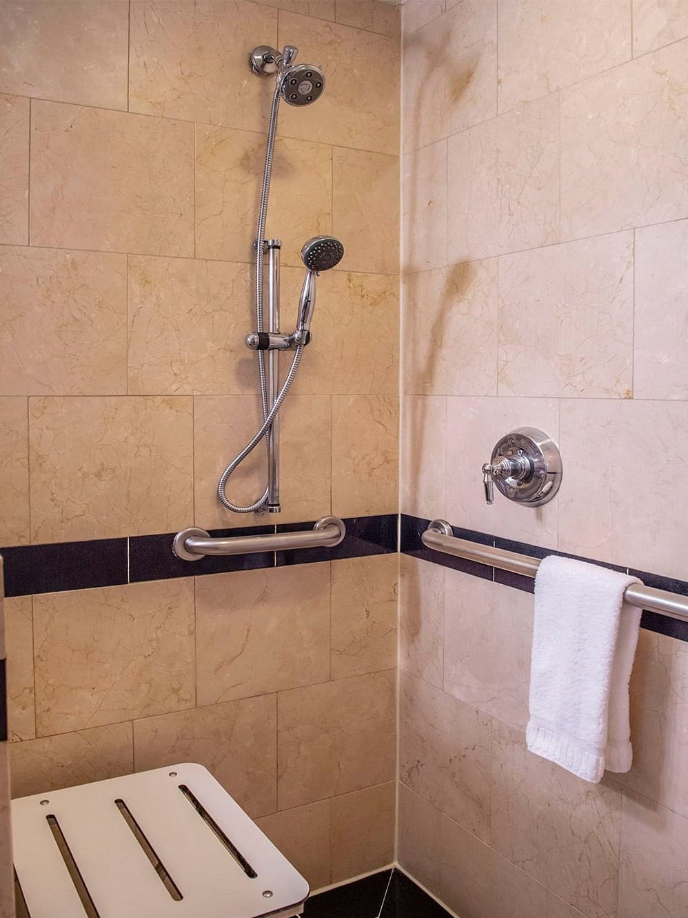 Bathroom, shower area and a folding seat in Accessible Premier City View at Warwick New York