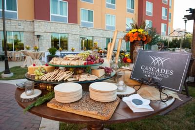table with cheese platter, plates and napkins