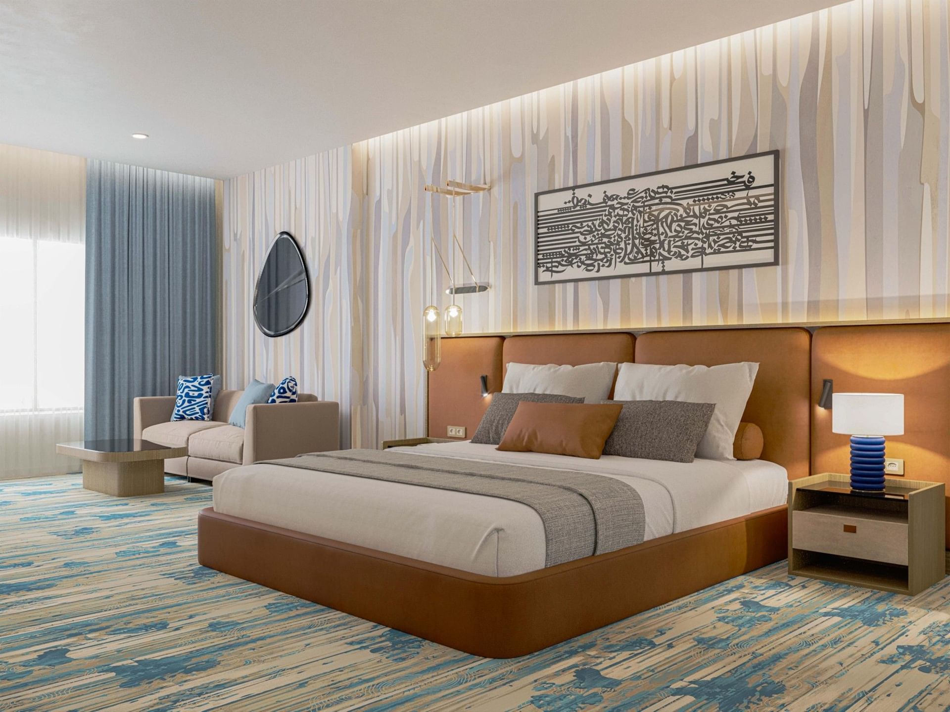 Elegant guest room featuring a bed between the side tables and a sofa under the mirror at Warwick Jeddah Hotel & Spa