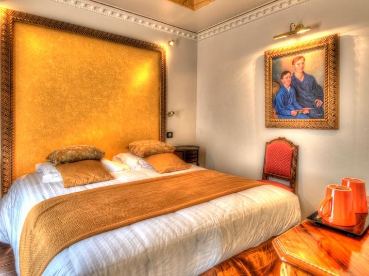 Chambre confortable avec lit, peinture et table au Hôtel Villa Aultia à Ault.