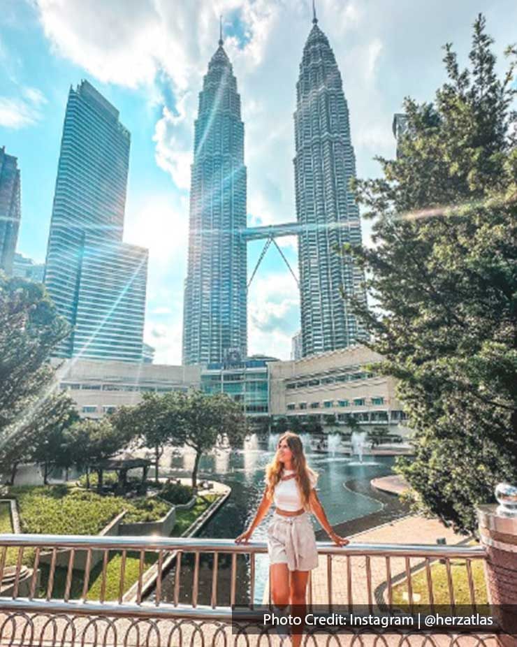 Girl posing with a backdrop of The Petronas Twin Towers, a famous attraction near Imperial Lexis Kuala Lumpur