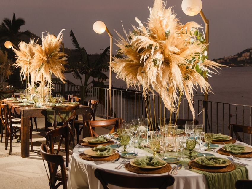 Camino Real I seaside dinner with lit globes and boho floral centerpieces at Camino Real Acapulco Diamante