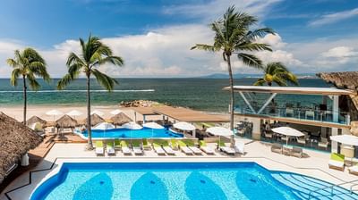 High-angle view of the luxury pool area and beautiful beachfront at Villa Premiere Boutique Hotel Puerto Vallarta.