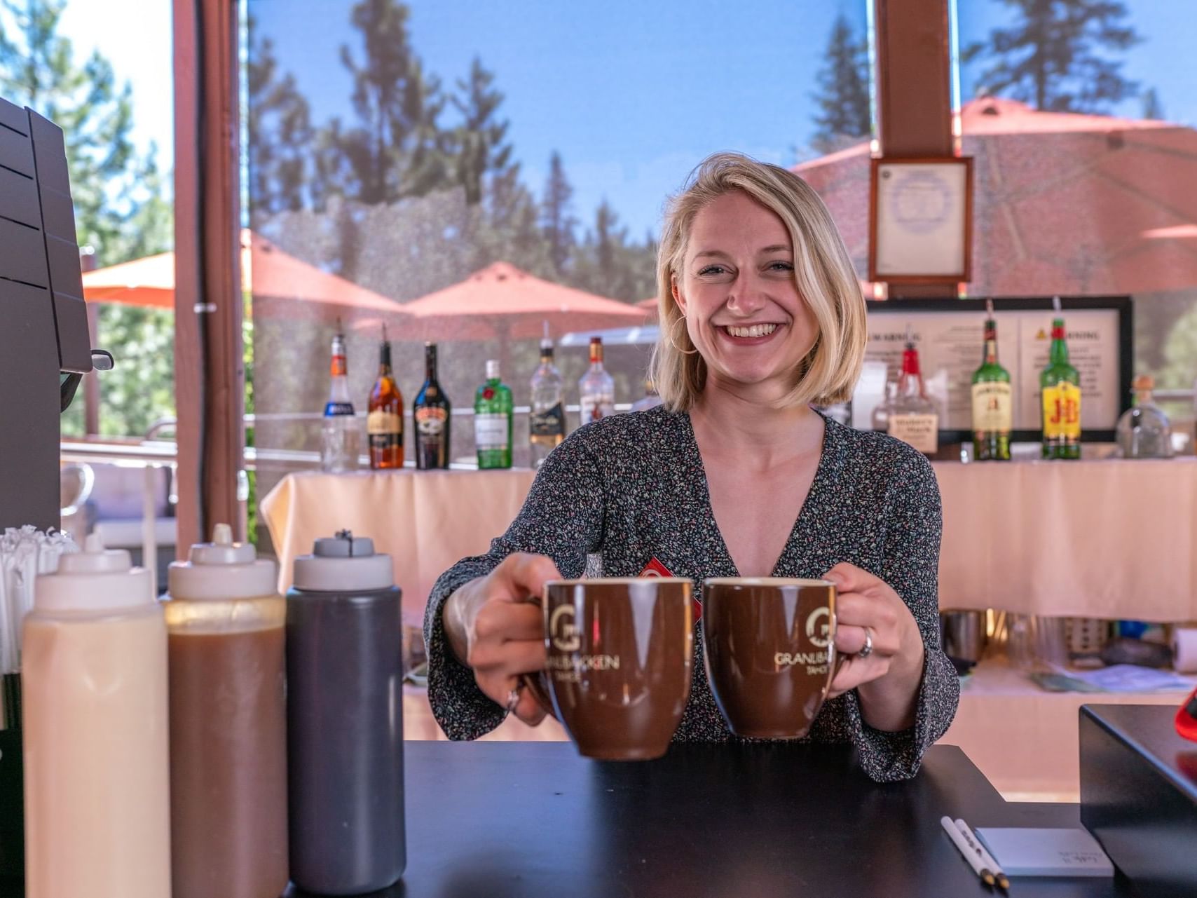 A lady with coffee mugs in Cedar House at Granlibakken Tahoe