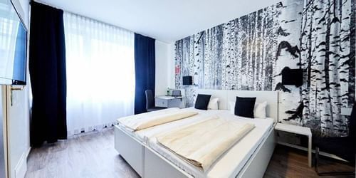 Bedroom with double beds & TV at Rhein Hotel St. Martin