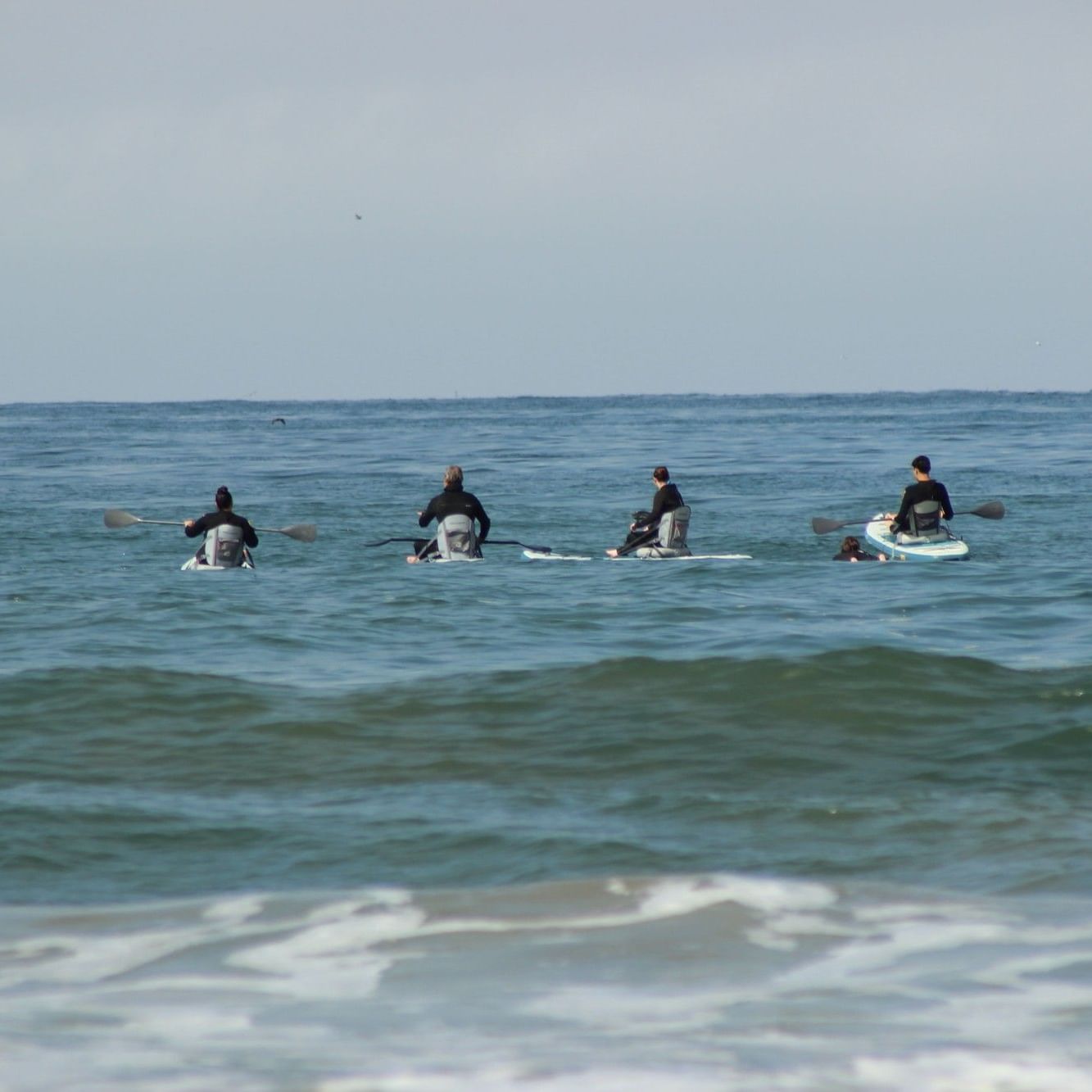 Kayakers and surfers in Pismo Beach