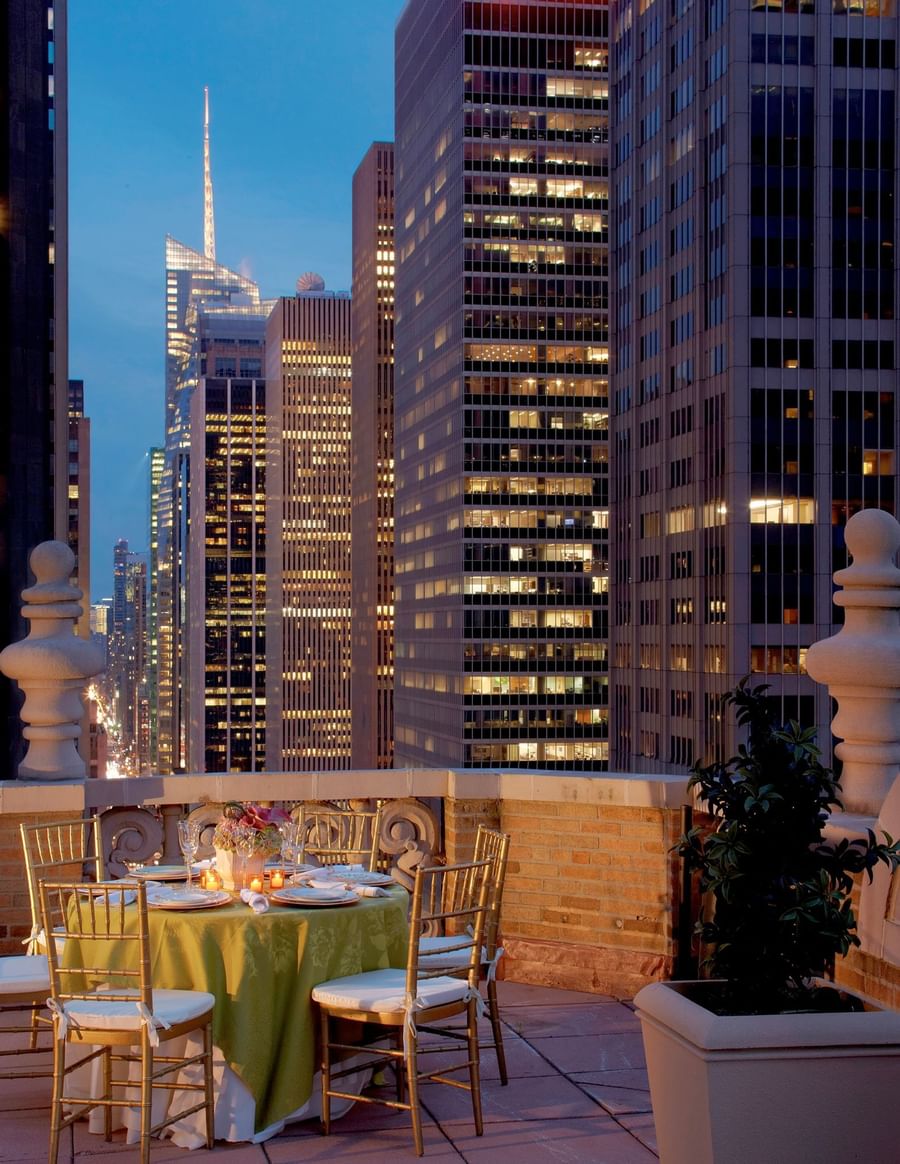 Private terrace dining table set against the glowing evening skyline of New York City at Warwick New York