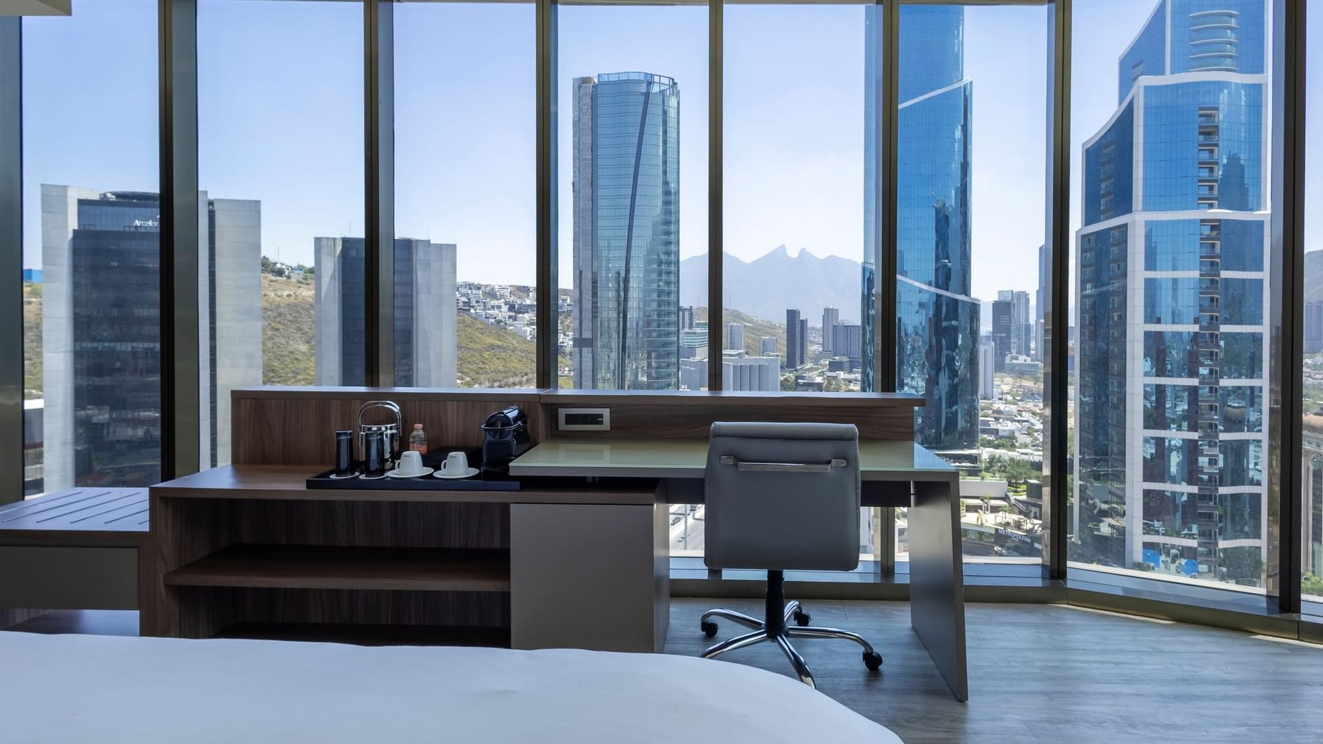 Junior Suite con escritorio y ventanales de piso a techo con vista panorámica en Camino Real Fashion Drive Monterrey
