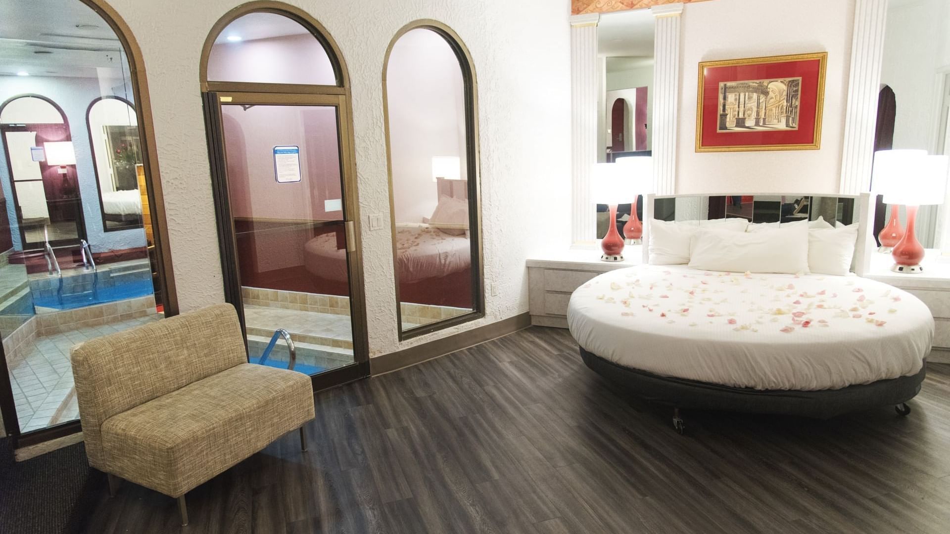 Stylish Garden of Eden Apple features a circular bed with rose petals and a door to the hot tub at Cove Pocono Resorts