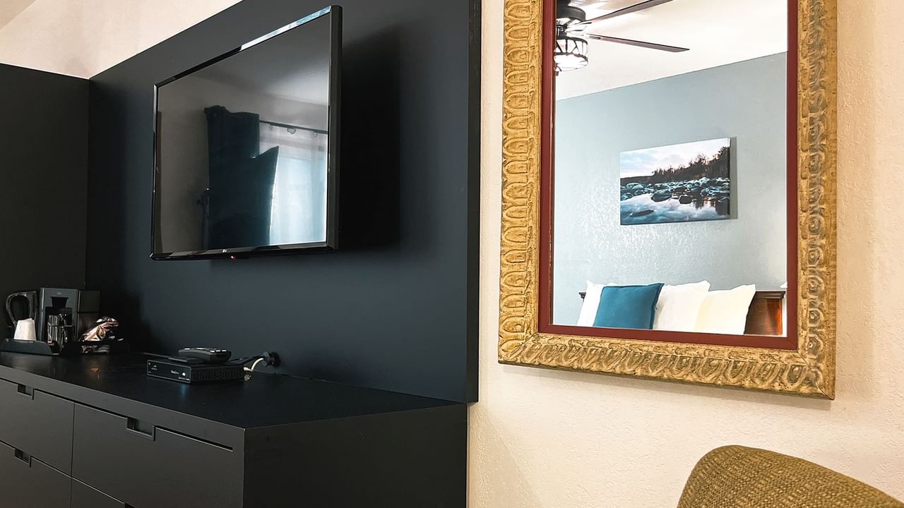 Room with TV, mirror, painting, and coffee maker