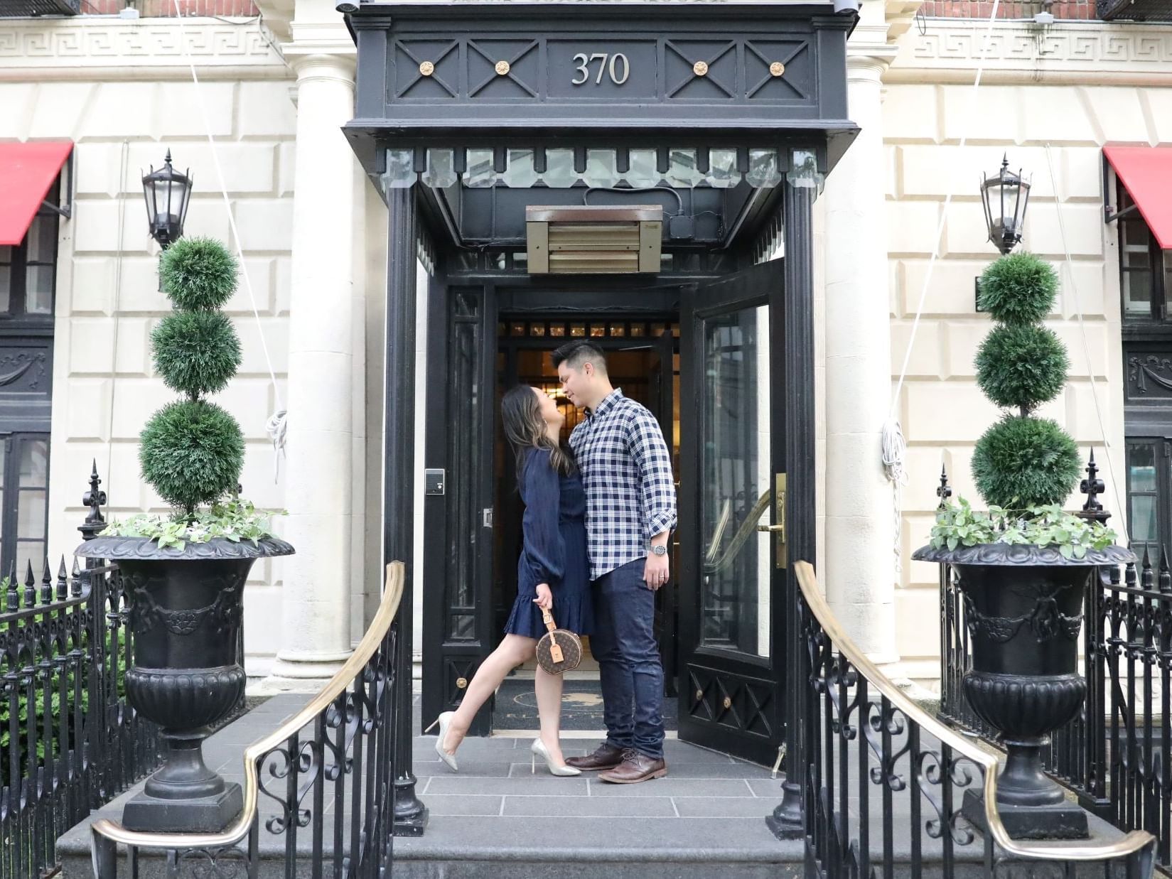 A couple standing in front of the entrance at The Eliot Hotel