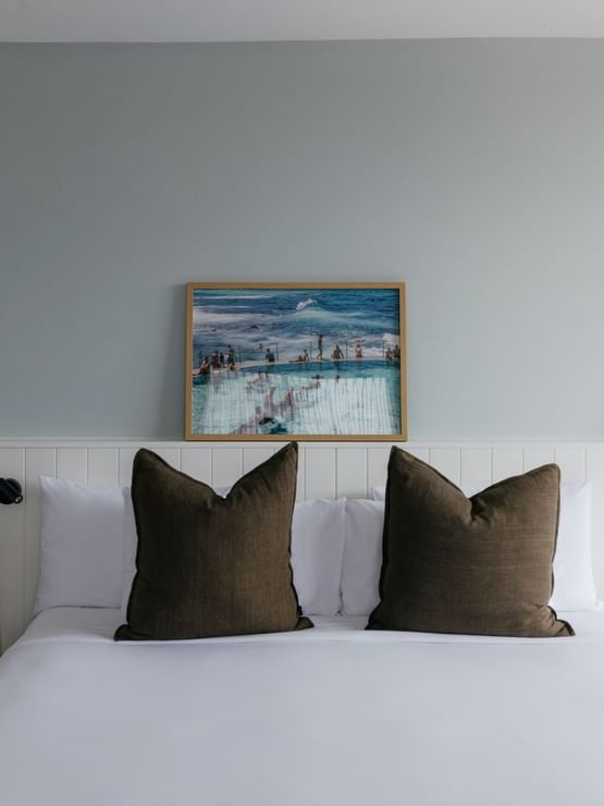 Atrium King at Elysium Manly with a grey sofa by a dining set under a chandelier overlooking ocean views