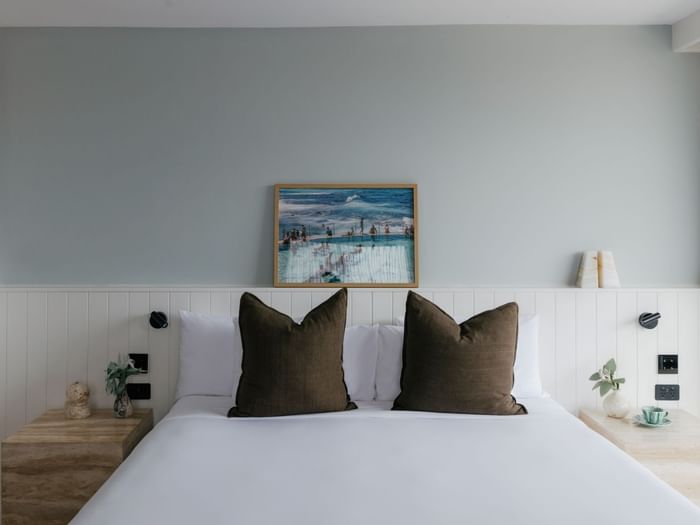 Atrium King at Elysium Manly with a grey sofa by a dining set under a chandelier overlooking ocean views