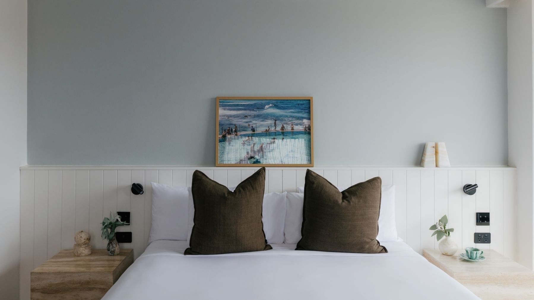 Atrium King at Elysium Manly with a grey sofa by a dining set under a chandelier overlooking ocean views