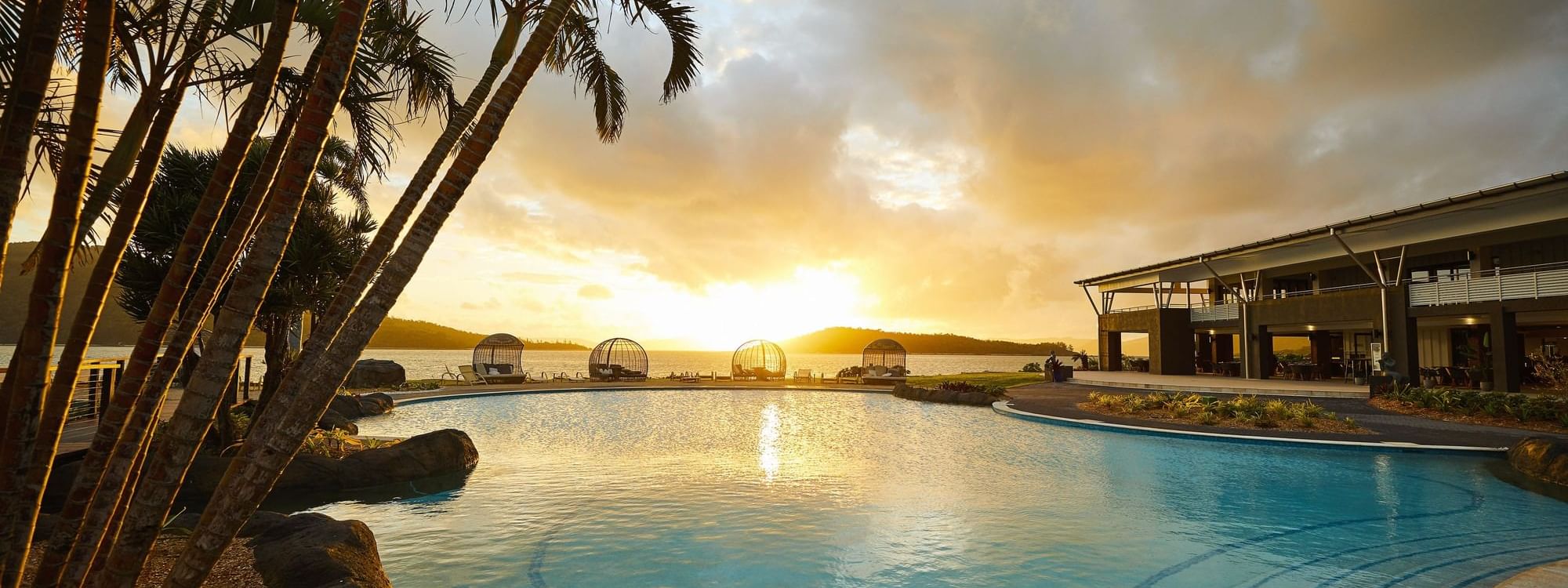 View of pool and trees during sunset at Daydream Island Resort
